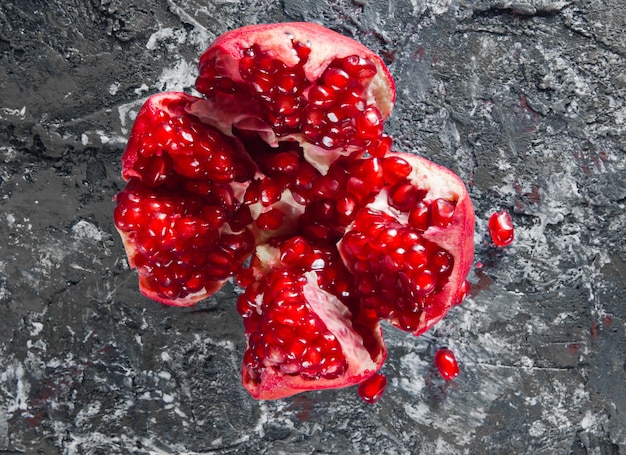 Ripe broken pomegranate on gray concrete background