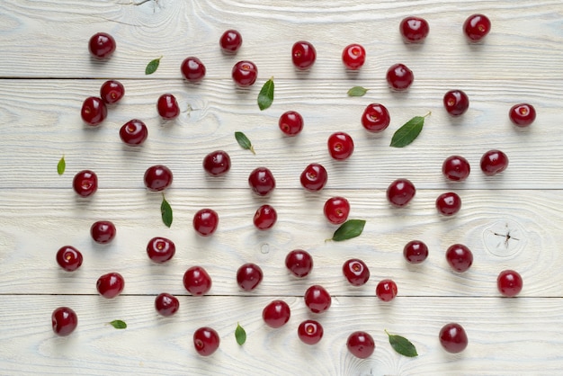 Ripe cherries scattered on a wooden background