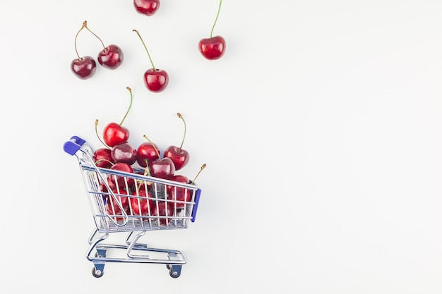 Ripe cherries in a shopping cart isolated