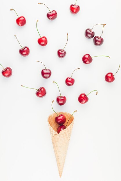 Ripe cherries in a waffle cone isolated