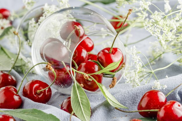 Ripe cherries with leaves on a napkin