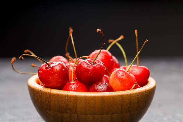 Ripe cherries in wooden bowl