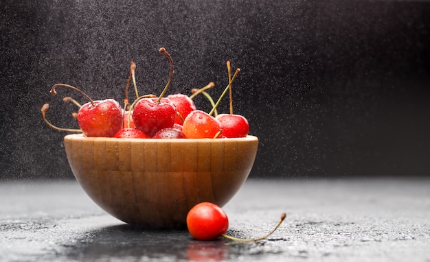 Ripe cherries in wooden bowl