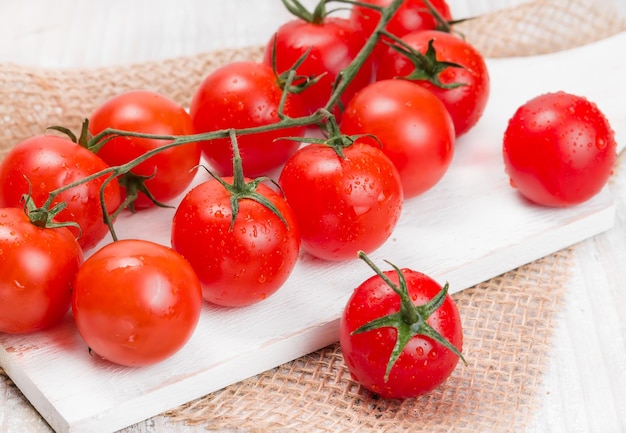 Ripe cherry tomatoes on a white board