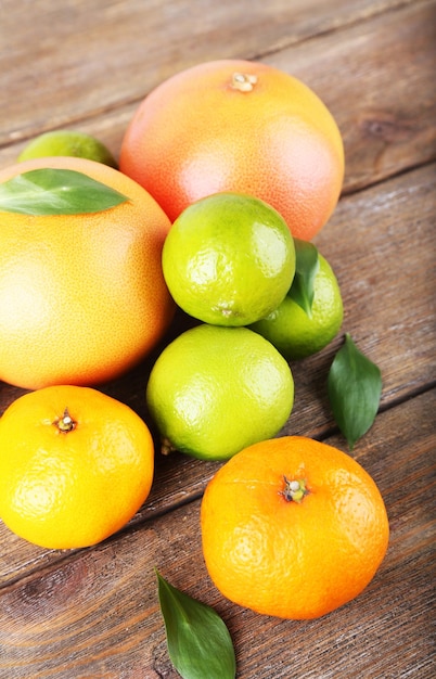 Ripe citrus with green leaves on wooden background