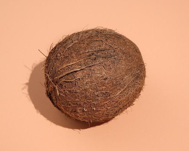 ripe coconut brown color lies on table with a shadow idea healthy food and exotic holidays