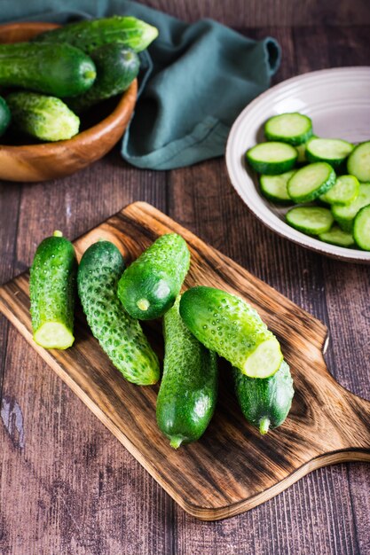 Ripe cucumbers on a cutting board on the table Organic diet food Vertical view