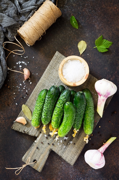 Ripe cucumbers with herbs on wooden board