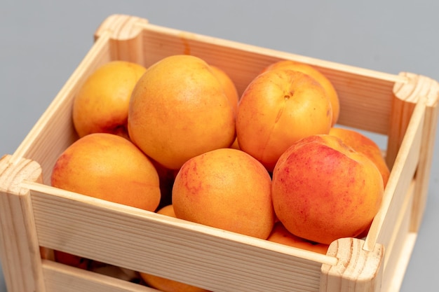 Ripe delicious apricots in a wooden box outdoors