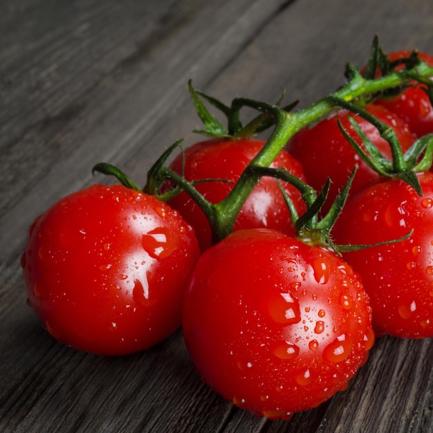 Ripe delicious red cherry tomatoes on a wooden background