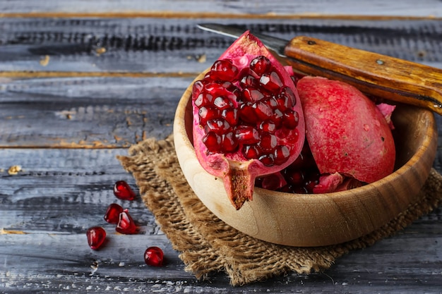 Ripe dissected pomegranate in wooden bowl