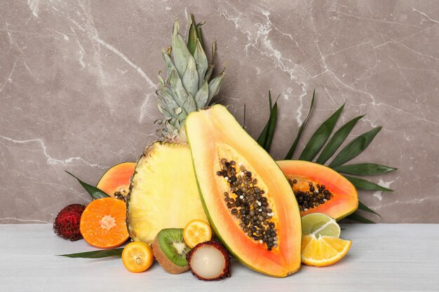 Ripe exotic fruits against gray textured background.