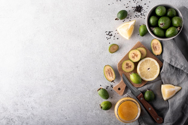 Ripe feijoa with lemon and honey on a white table