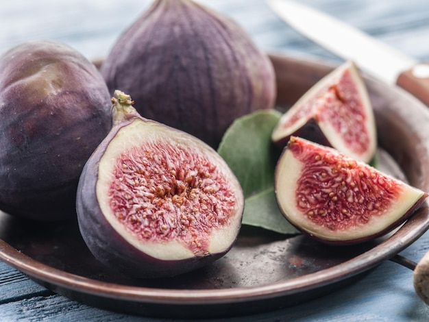 Photo ripe fig fruits on in the old tray on the wooden table