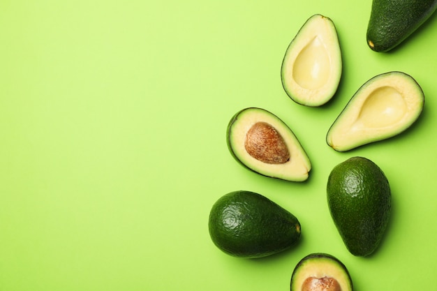 Photo ripe fresh avocado on green background, top view