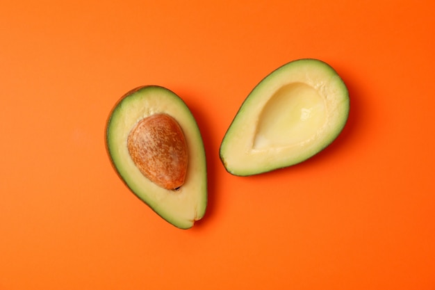 Ripe fresh avocado on orange background, top view