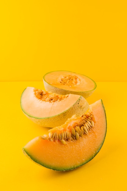 Photo ripe fresh cantaloupe slices on yellow background