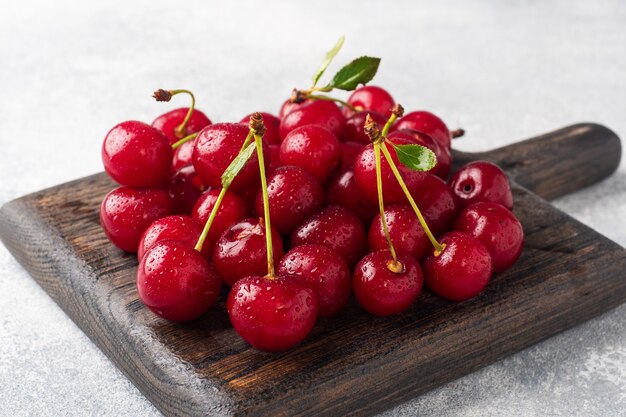 Ripe fresh cherry berries on a wooden cutting board. Copy space.