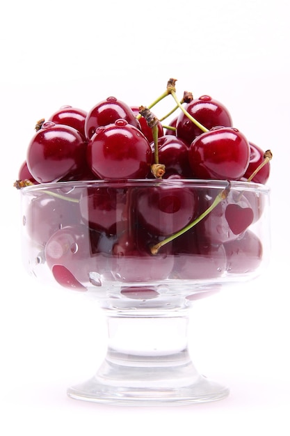 Ripe fresh cherry in the glass isolated on white background