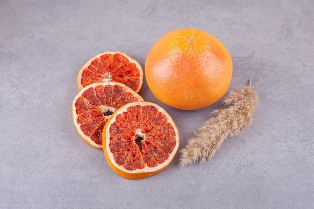 Ripe fresh grapefruit placed on stone surface.