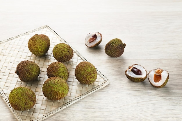 Ripe and fresh green lychees on wooden table