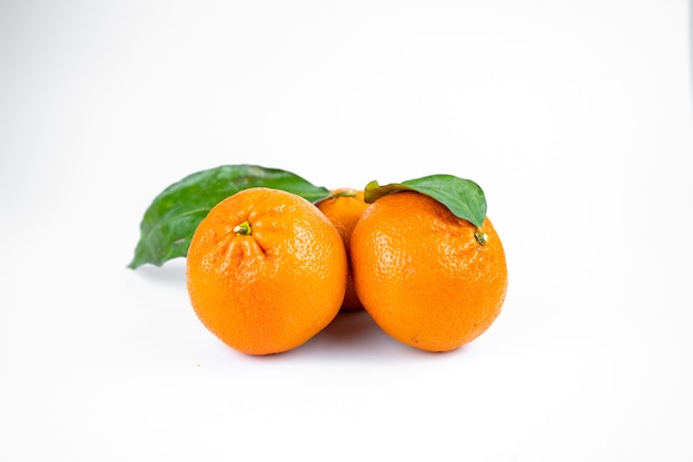 Ripe fresh juicy tangerines with leaves on white background