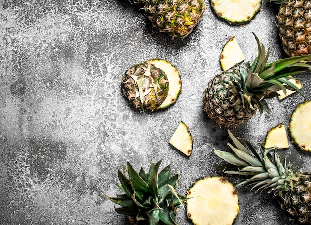 Ripe fresh pineapples on rustic table.