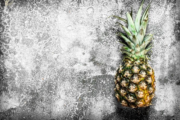 Ripe fresh pineapples on rustic table.