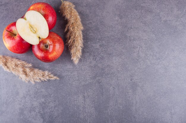 Ripe fresh red apples placed on a stone background. 