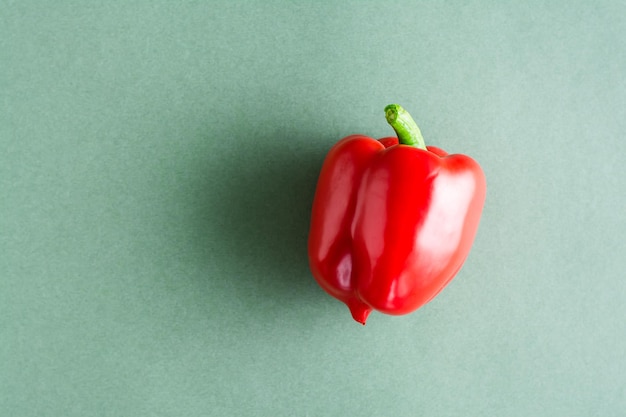 Ripe fresh red bell pepper on a green background Vegetarian food Top view