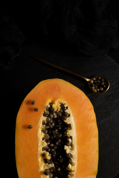 Ripe and freshly cut papaya. Fresh and tropical fruit with dark background