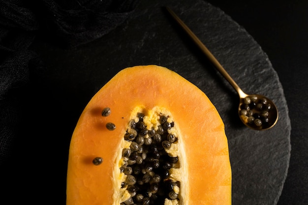 Спелая и свежесрезанная папайя. Свежие и тропические фрукты с темным фоном