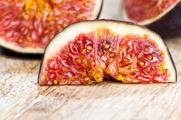 Ripe fruit in the kitchen during the preparation of fruit salad, healthy red delicious Fig pulp with seeds, ripe figs cut into pieces, close up