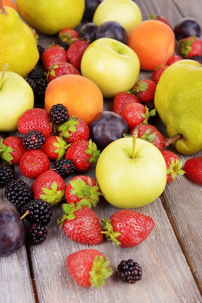 Ripe fruits and berries on wooden background