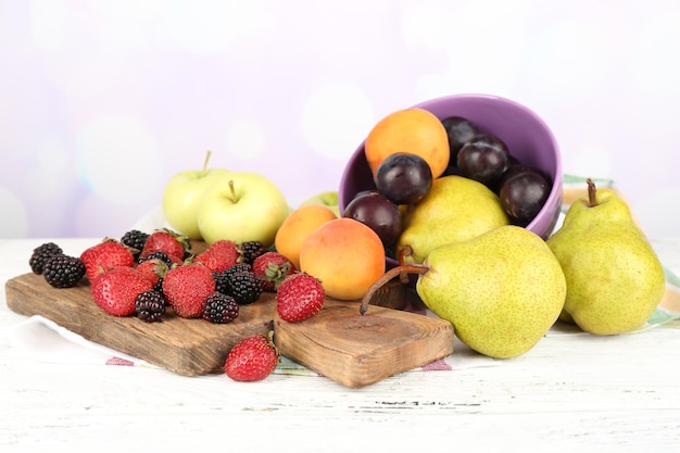 写真 ボウルに熟した果物と明るい背景のテーブルの上の果実