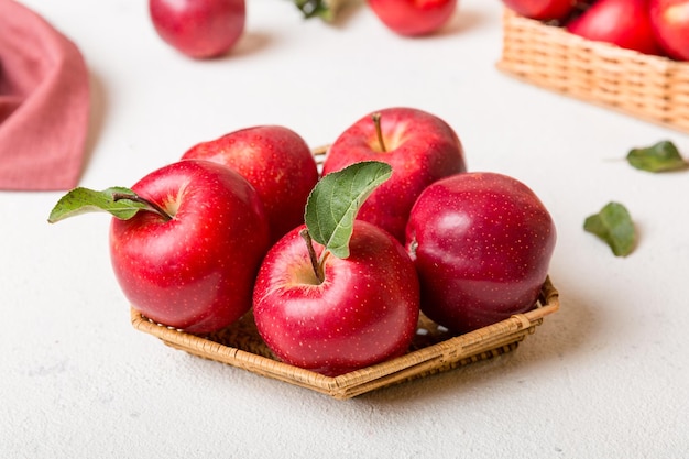 Ripe garden apple fruits with leaves in basket on wooden table Top view flat lay with copy space