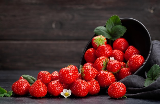 Ripe garden strawberry in bowl on wooden table With copy space