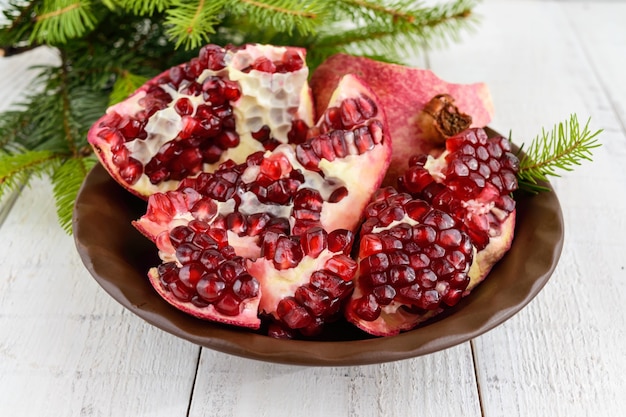 Ripe garnet have broken into pieces on a white background. Juicy Asian fruit. Close up.