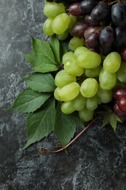 Ripe grape and leaves on black smokey background