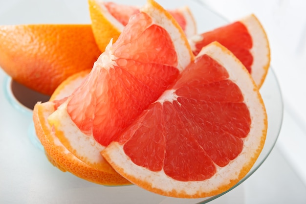 Ripe grapefruit slices in a juicer in the kitchen