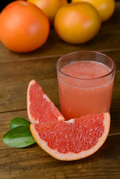 Фото Спелый грейпфрут с соком на столе крупным планом