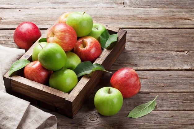 사진 텍스트를 위한 공간이 있는 나무 테이블에 익은 녹색 및 빨간색 사과