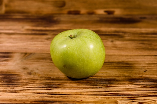 Ripe green apple on a wooden table