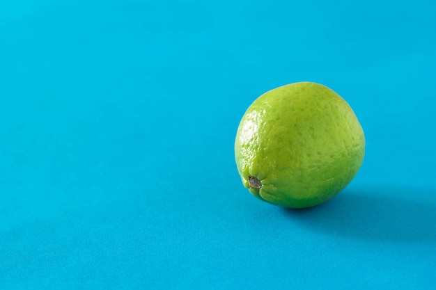 Calce verde matura su sfondo blu. agrumi per fare un drink.