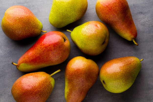 Ripe green pears on the gray surface.