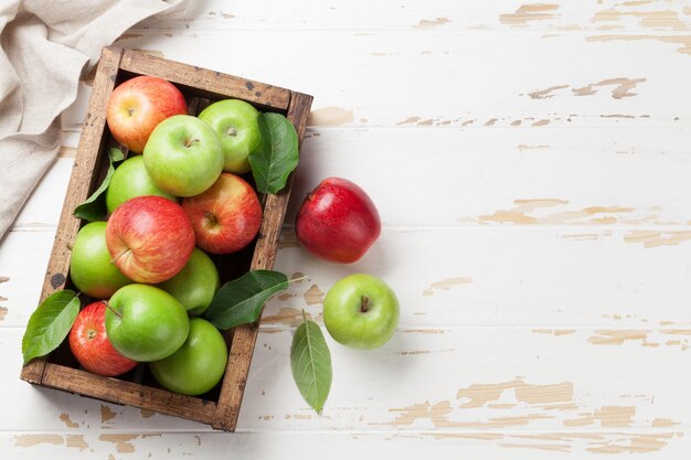 Ripe green and red apples in wooden box Top view with space for your text