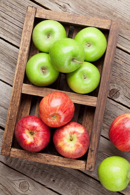 木製のテーブルの上に熟した緑と赤のリンゴの上面図