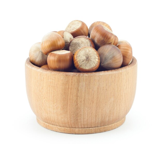 Ripe hazelnuts wooden saucer on a white surface