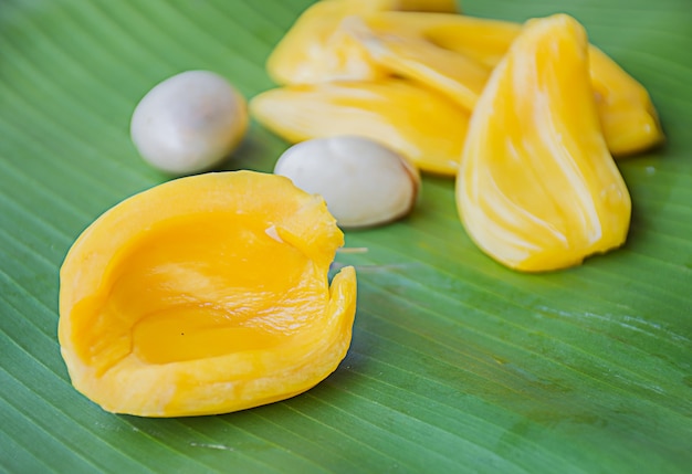 The ripe jackfruit and peeled seeds are placed on banana leaves