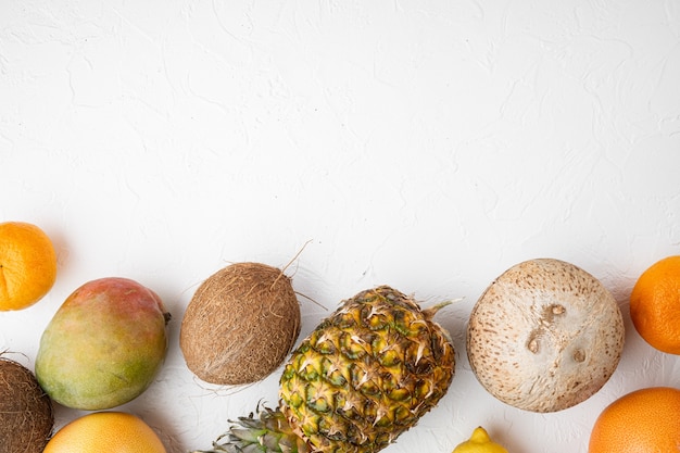 Ripe juicy fresh tropical fruits set, on white stone table background, top view flat lay, with copy space for text